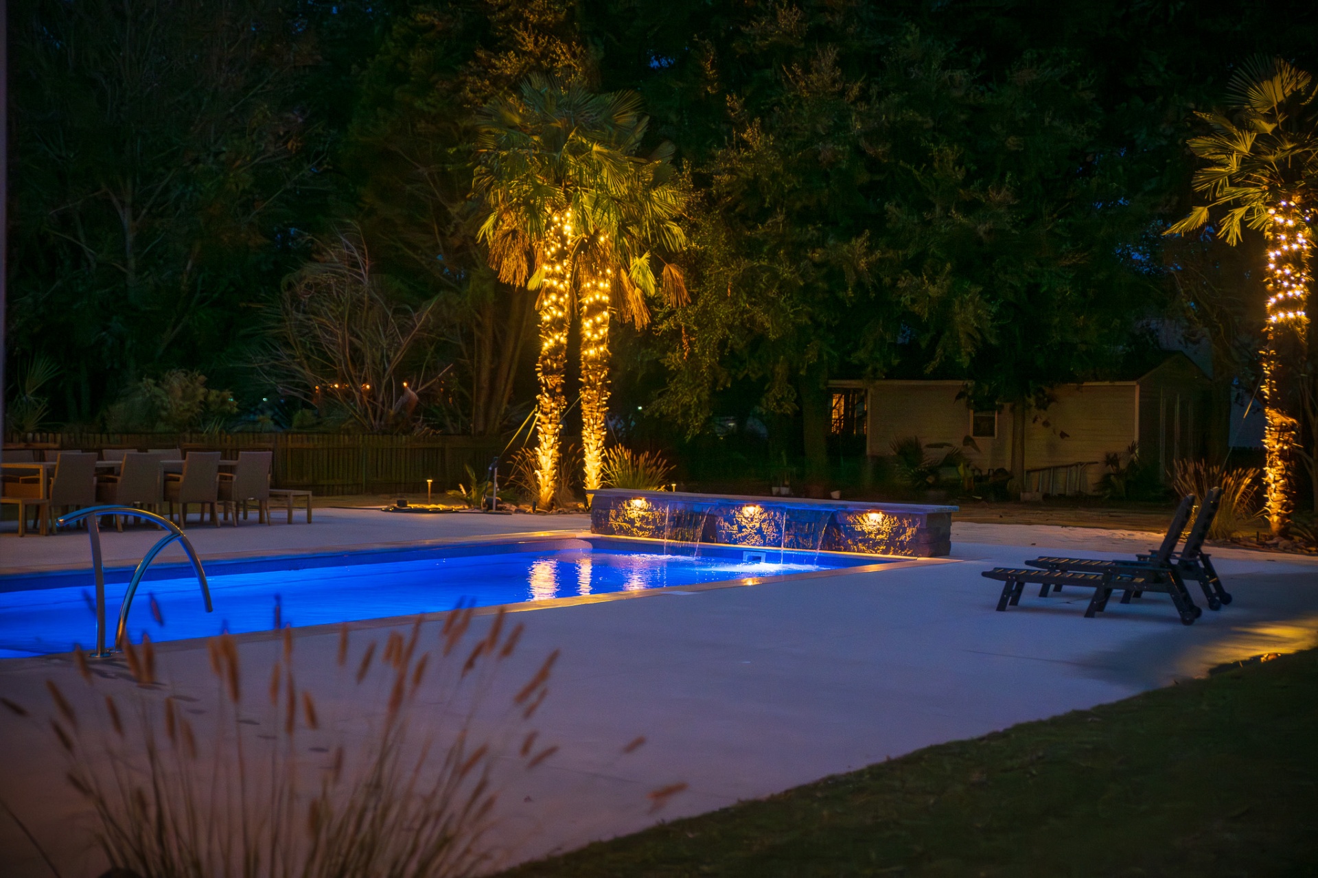 Pool and landscape at night with layered architectural lighting