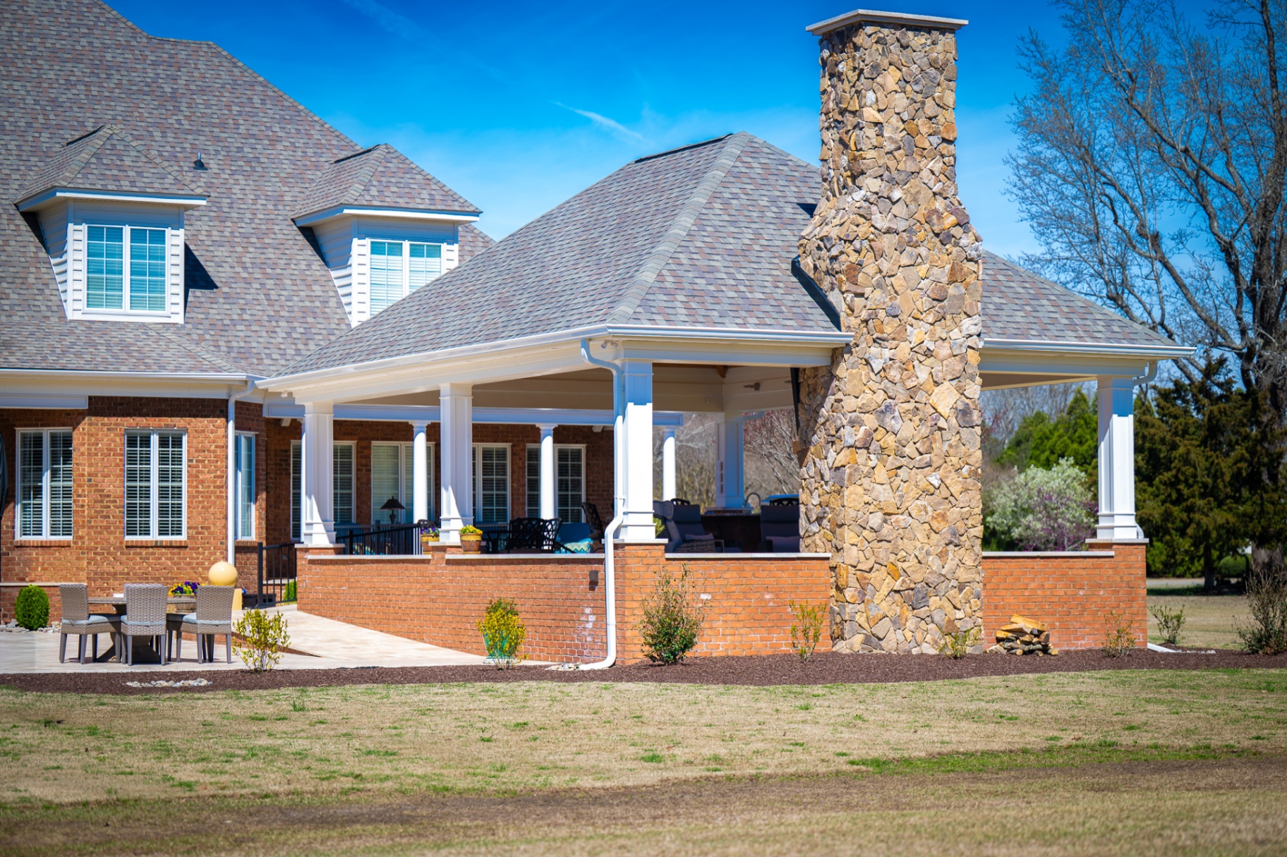 Covered outdoor living porch with hardscape terrace