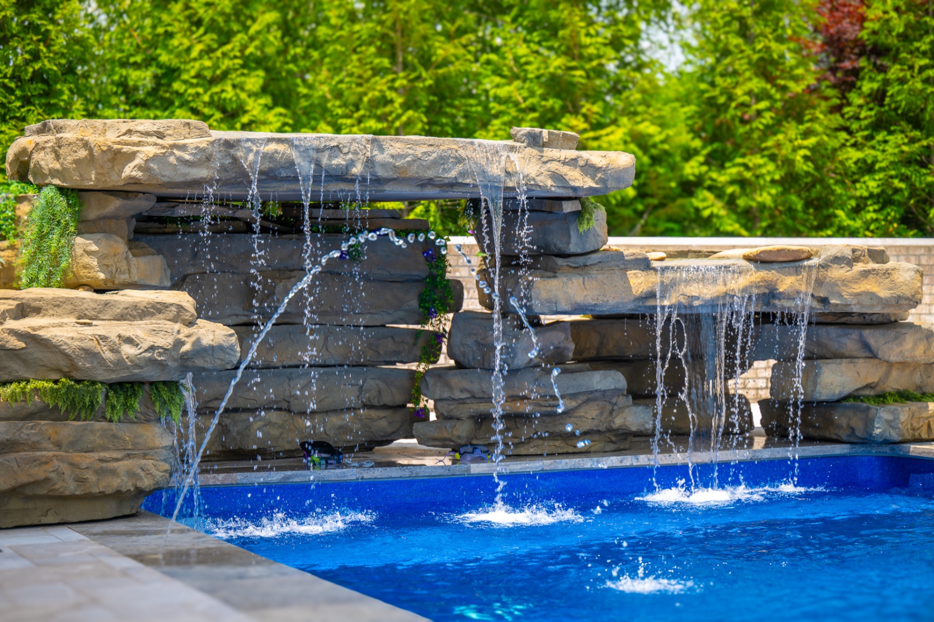 Rock waterfall feature spilling into blue pool