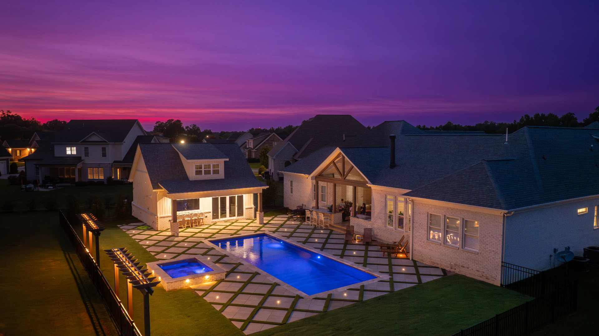 Twilight aerial view of a custom Bluevue pool and spa