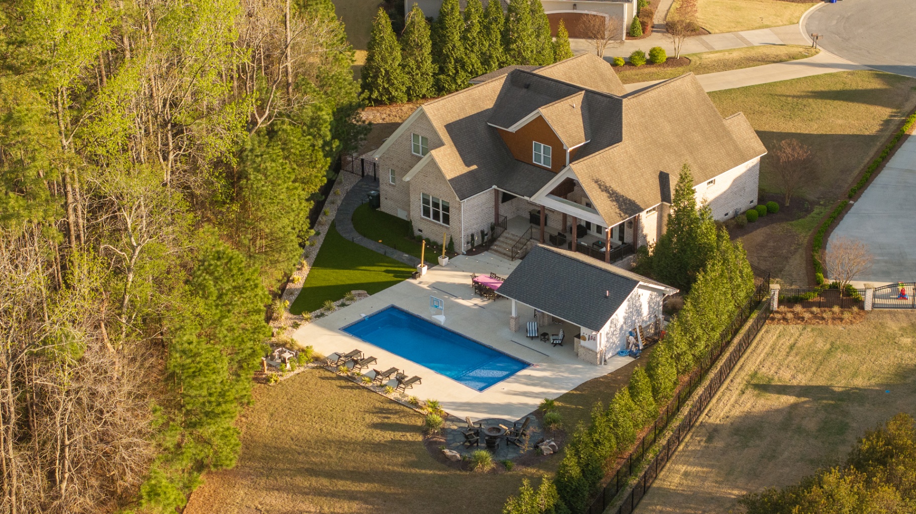 Aerial view of brick estate with pool and pavilion