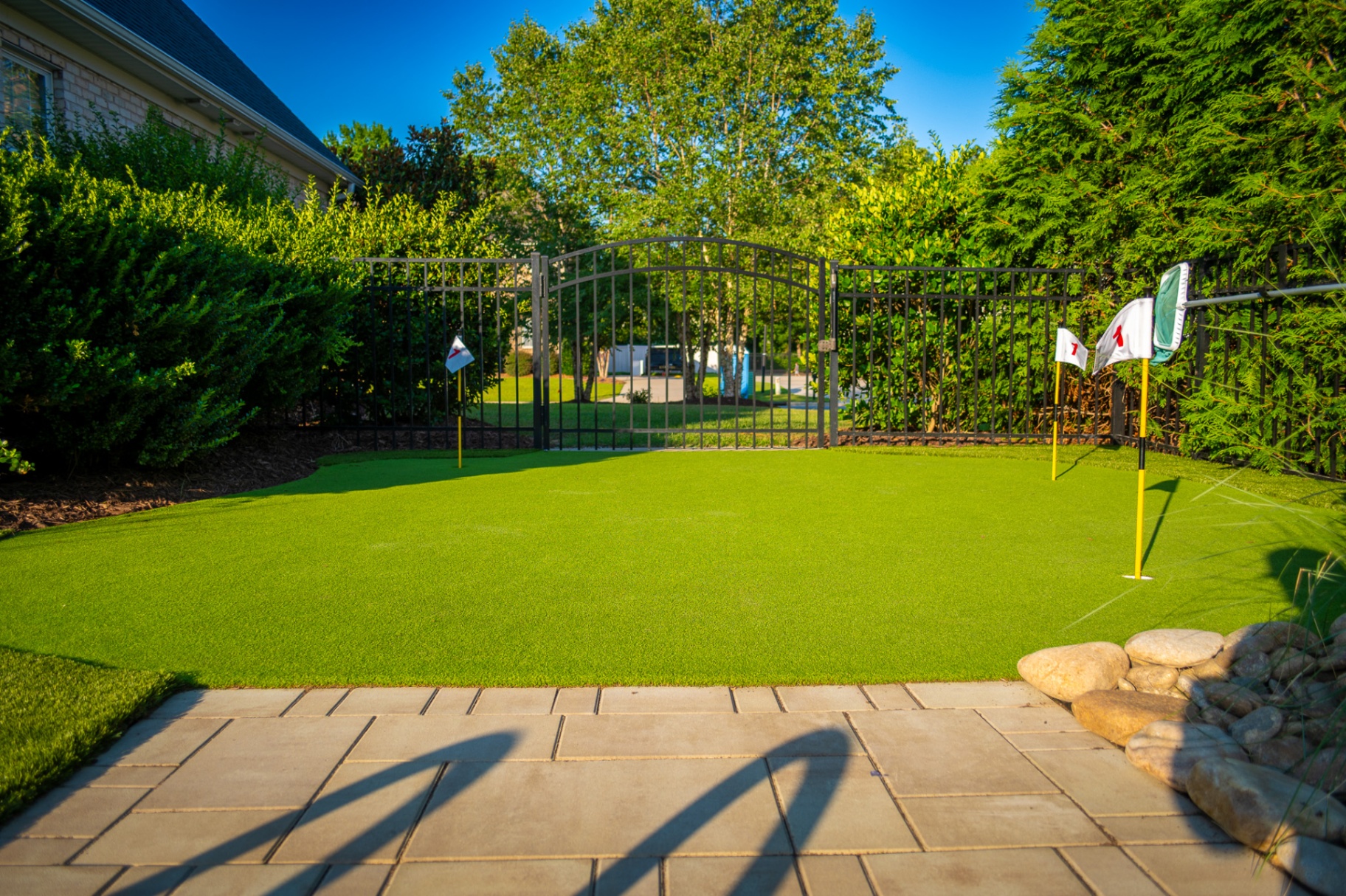 Synthetic putting green integrated into a designed landscape